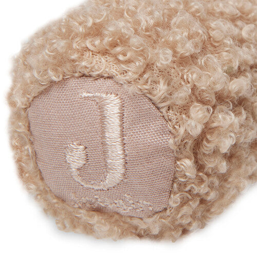 Detail van de onderkant van de jollein knijprammelaar teddybeer met een geborduurde 'J'.