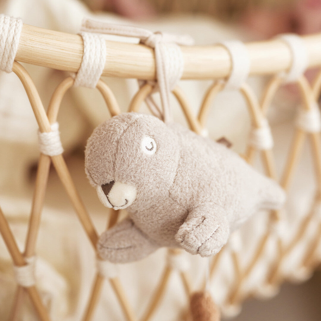 Detail van het Jollein pluchen zeehond muziekdoosje hangend aan een babywiegje.