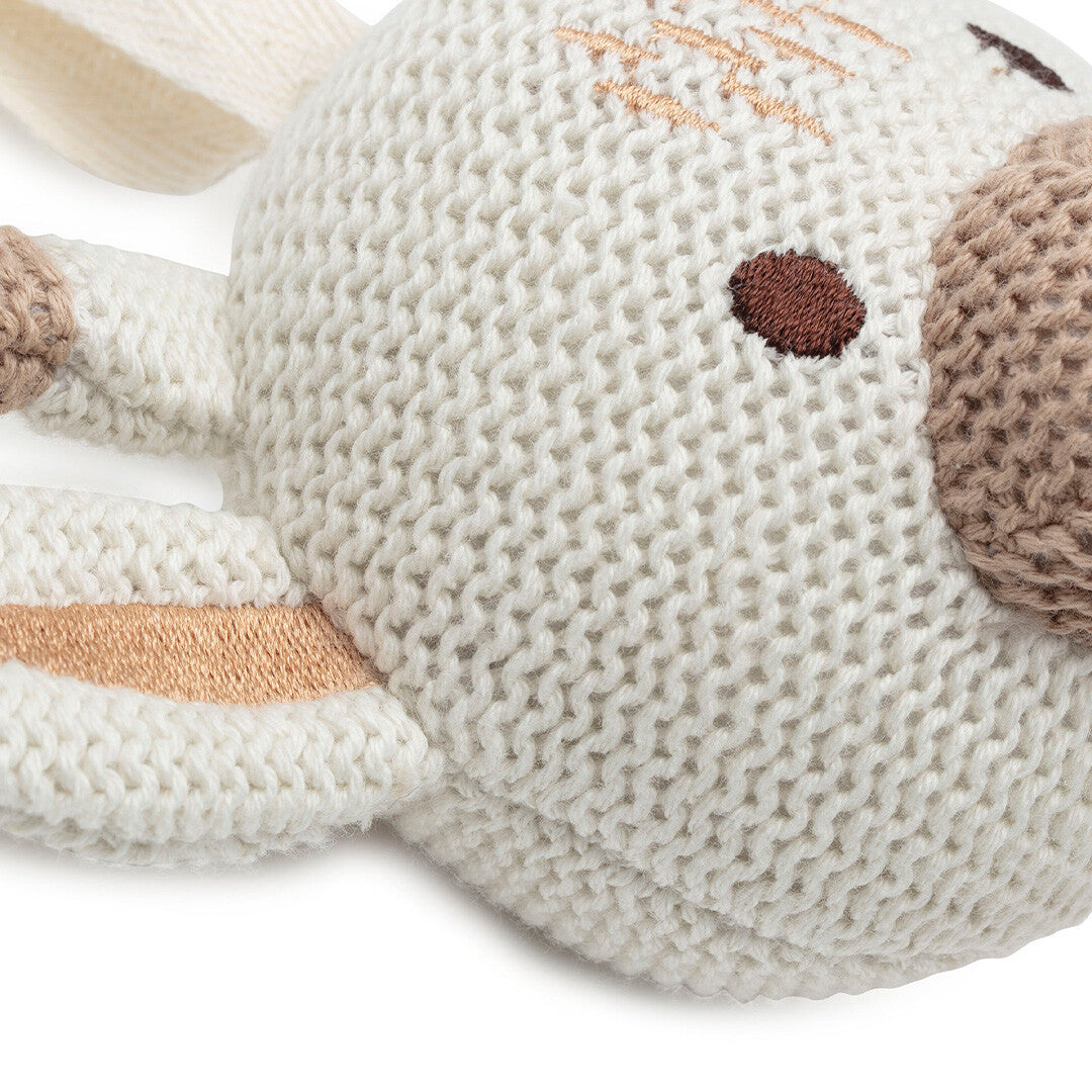 Detailopname van het Jollein babyspeelgoed muziekdoosje, met de gebreide textuur en geborduurde ogen en neus van de giraffenkop.