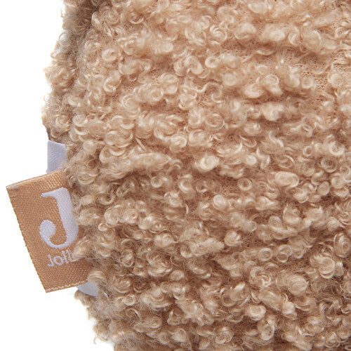 Detail van de pluizige textuur van het Jollein muziekdoosje met een merklabel.