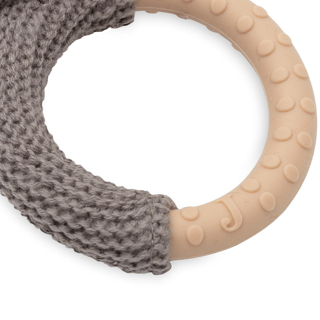 Detail van de rammelaar met bijtring, met de gebreide grijze stof en de beige rubberen ring met nopjes.