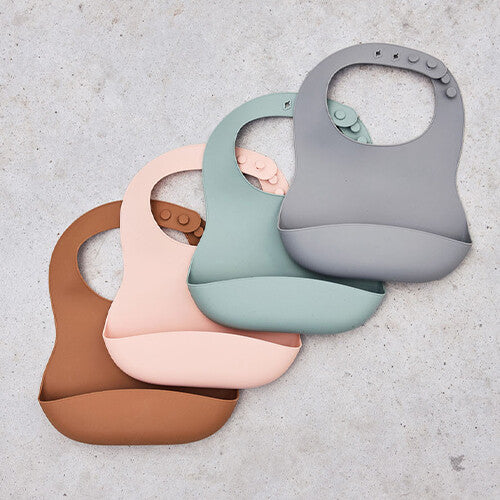Collectie Jollein siliconen slabbetjes in verschillende kleuren: bruin, roze, groen en grijs.