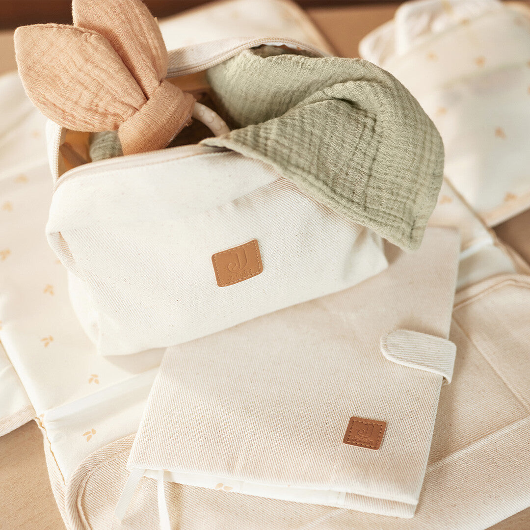 Jollein beige twill toilettas gevuld met babyspeelgoed en een bijpassend verschoonmatje.