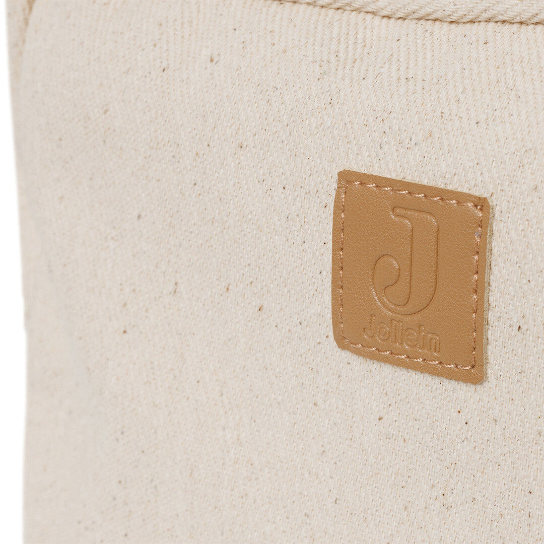 Detail van het bruine Jollein logo op de beige twill stof van de toilettas.