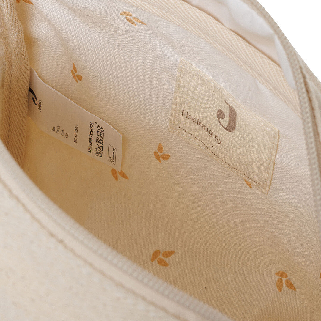 De binnenkant van de Jollein beige twill toilettas met lichtgekleurde voering en bladerenpatroon.