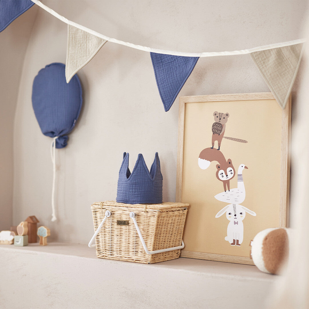 Jollein vlaggenslinger met blauwe en beige vlaggetjes boven een mandje en dierenposter.