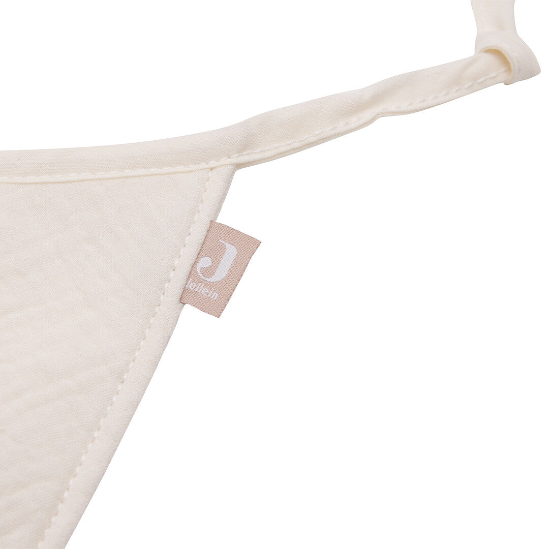 Detail van een ivoorkleurig vlaggetje van de Jollein stoffen slinger met merklabel.