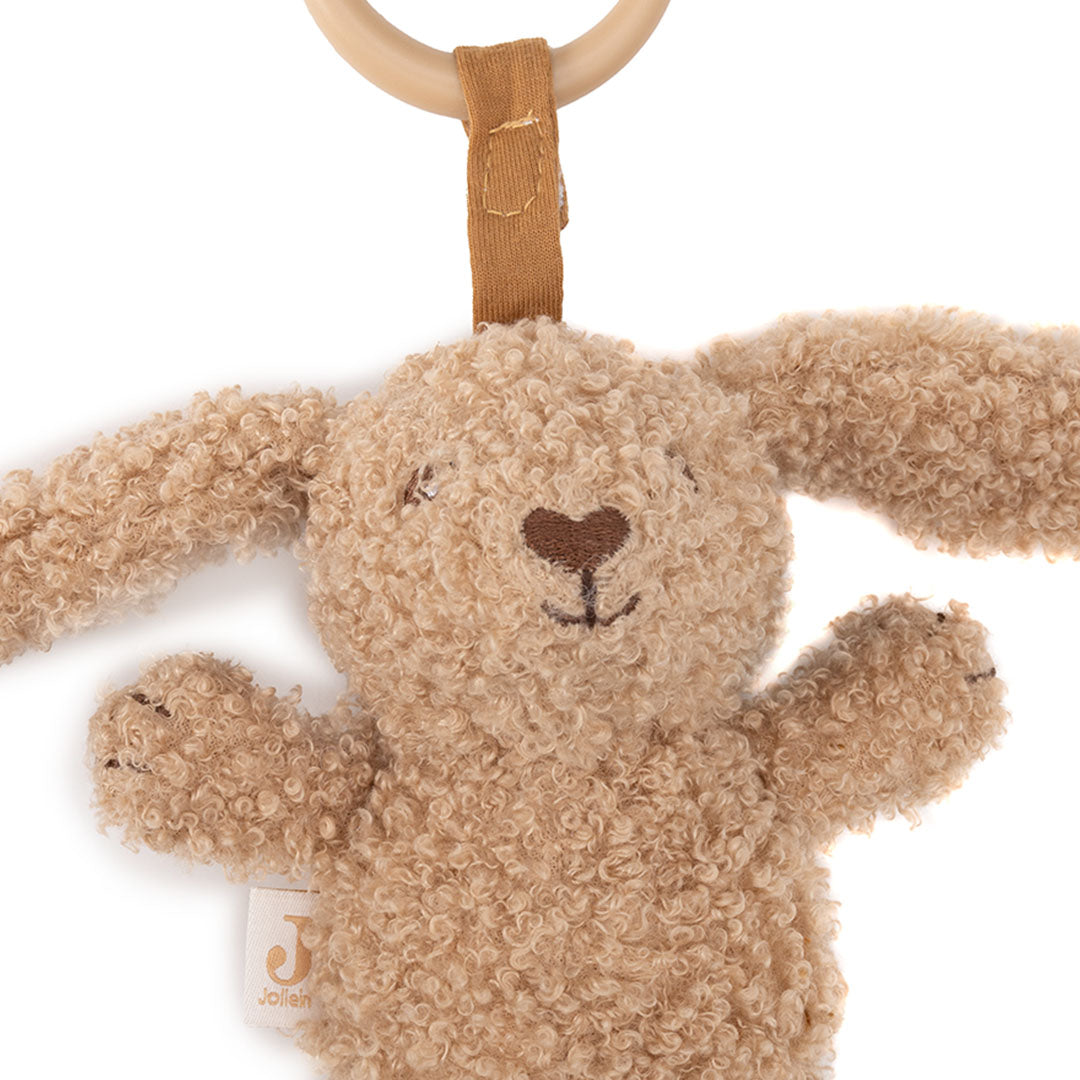 Detailopname van de Jollein wagenhanger in de vorm van een beige konijn met een houten ring.