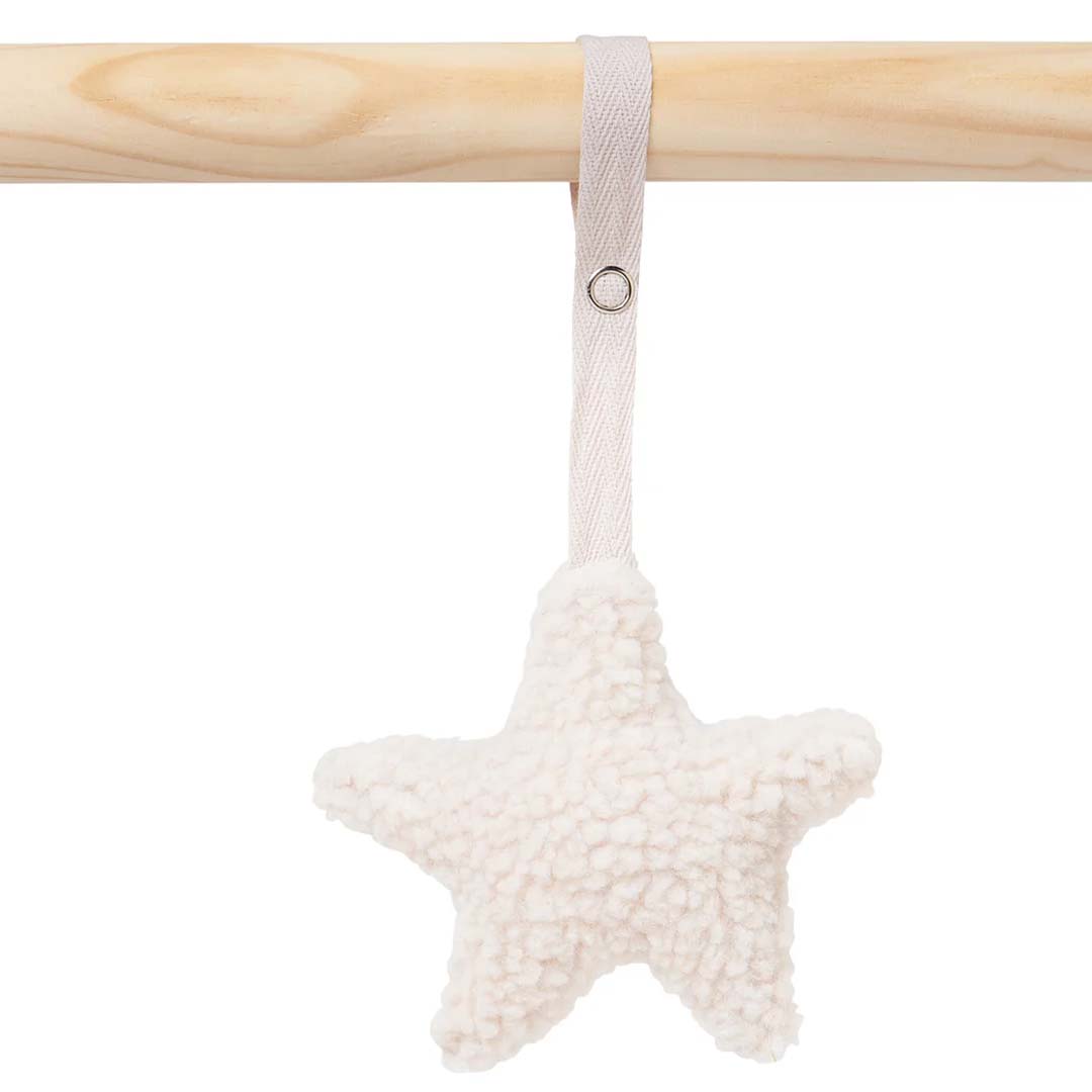 Close-up van een beige polyester ster-vormig speeltje hangend aan een houten staaf.