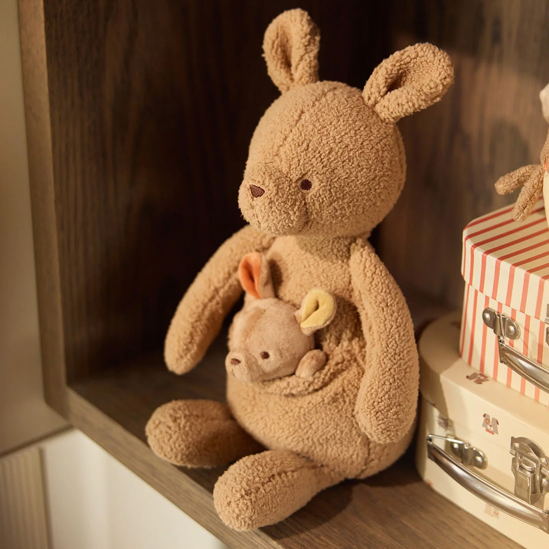 Jollein pluchen knuffelkangoeroe met baby in de buidel, zittend op een houten plank.