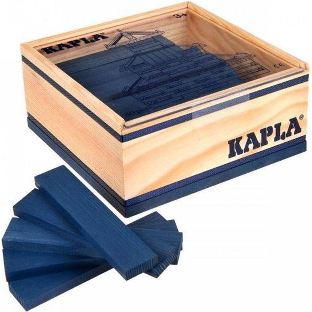 Een Kapla houten doos met een transparante deksel en een waaier van donkerblauwe Kapla houten blokken ervoor.