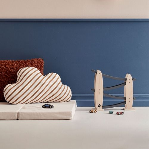 Kids Concept houten autobaan met drie speelgoedauto's in een kinderkamer.