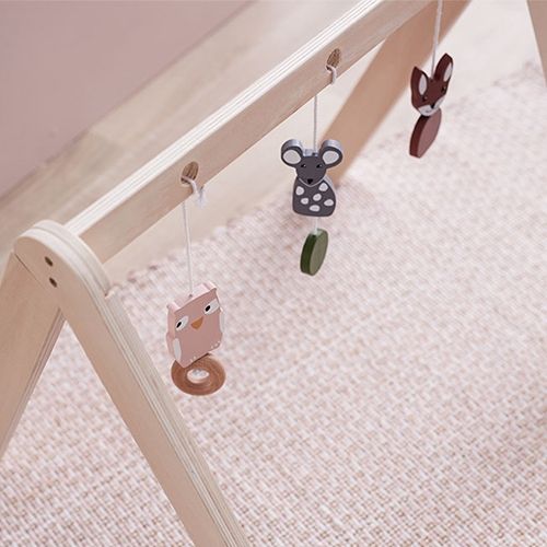 Kids concept houten babygym met hangspeelgoed in de vorm van een uil, muis en vos op een licht tapijt.