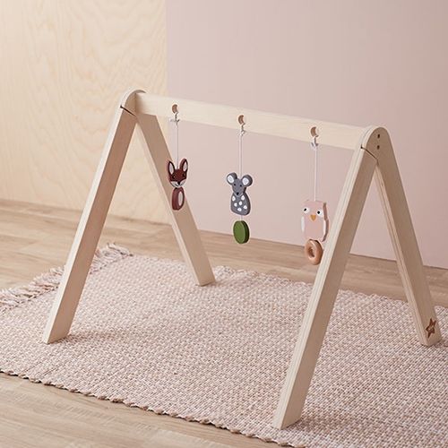 Kids concept houten babygym met hangspeelgoed in de vorm van een vos, muis en uil op een licht tapijt.