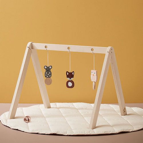 Kids concept houten babygym met hangspeelgoed van dieren op een ronde, gewatteerde speelmat.