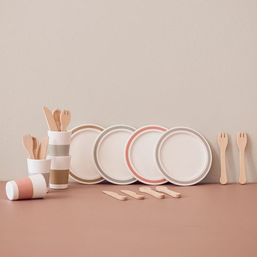 kids concept houten speelgoedservies met veelkleurige borden, bekers en bestek op een roze ondergrond.
