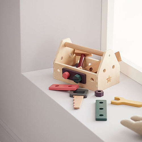 Kids concept houten gereedschapskist met gereedschappen en onderdelen op een witte vensterbank.