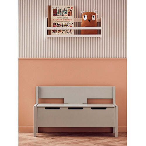 Kids Concept mintgroene kinderbank met opbergruimte in een kinderkamer met een boekenplank erboven.