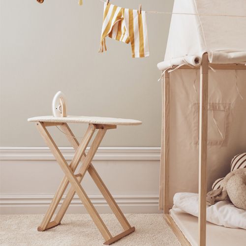 Kids concept speelgoed strijkplank met strijkbout in een kinderkamer, met wasgoed aan een lijn.