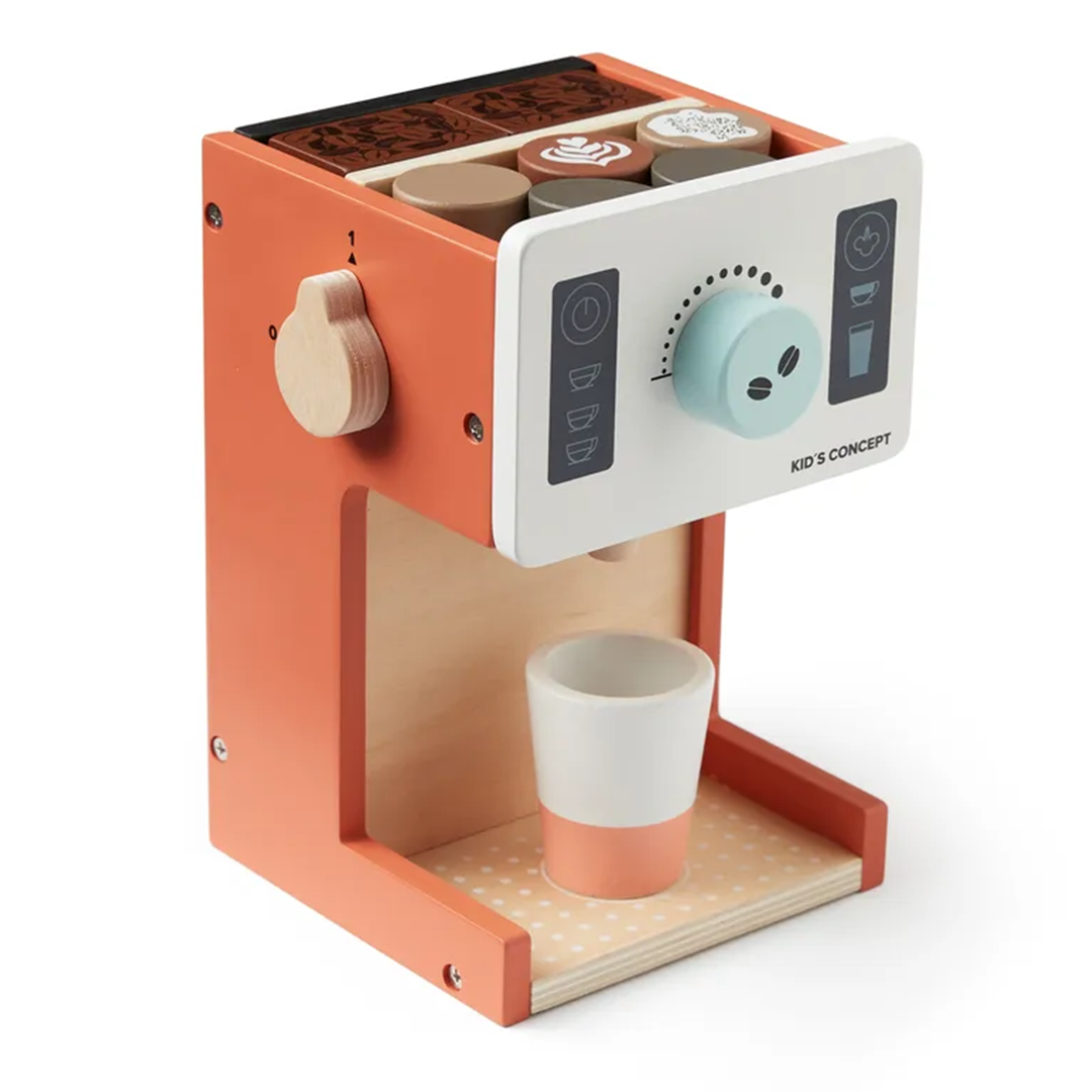 Close-up van de Kids Concept houten koffiemachine speelset met oranje accenten en een kopje eronder, op een witte achtergrond.