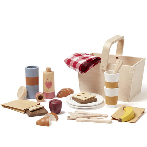 De Kids Concept houten picknick speelset met mand en alle speelgoedeten, bestek en servies uitgestald.