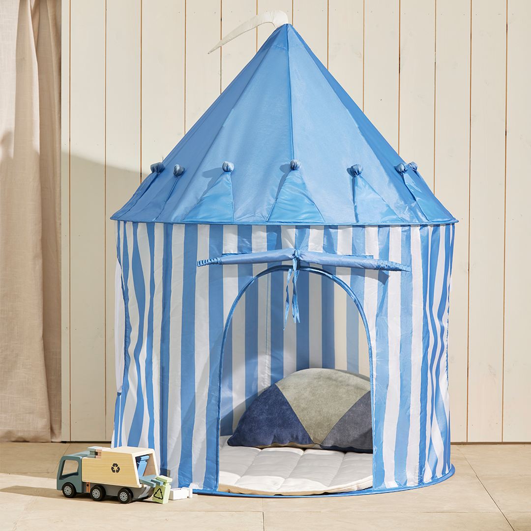 Kids Concept speeltent met blauw-witte strepen, staand op een houten vloer met een kussen erin.