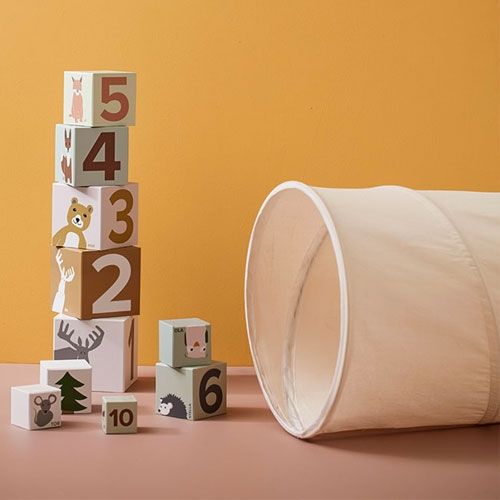 Kids Concept naturelkleurige speeltunnel met ernaast een stapel houten speelblokken met cijfers en dieren.
