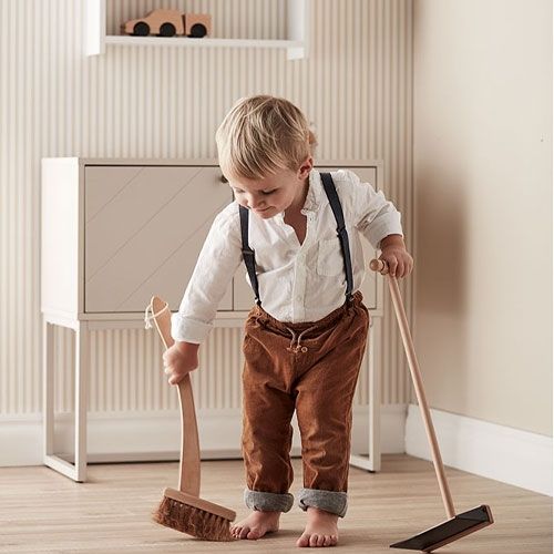 Een jong kind veegt de vloer met de Kids Concept houten speelgoed reinigingsset.