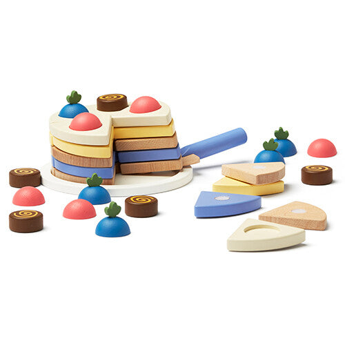 Kids Concept houten speelgoedtaart waarvan een stuk wordt geserveerd met de taartschep, met losse toppings.