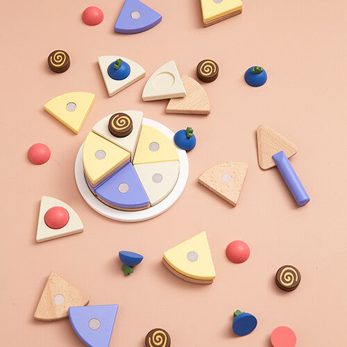 Kids Concept houten speelgoedtaart set, van bovenaf gezien, met alle losse onderdelen verspreid.