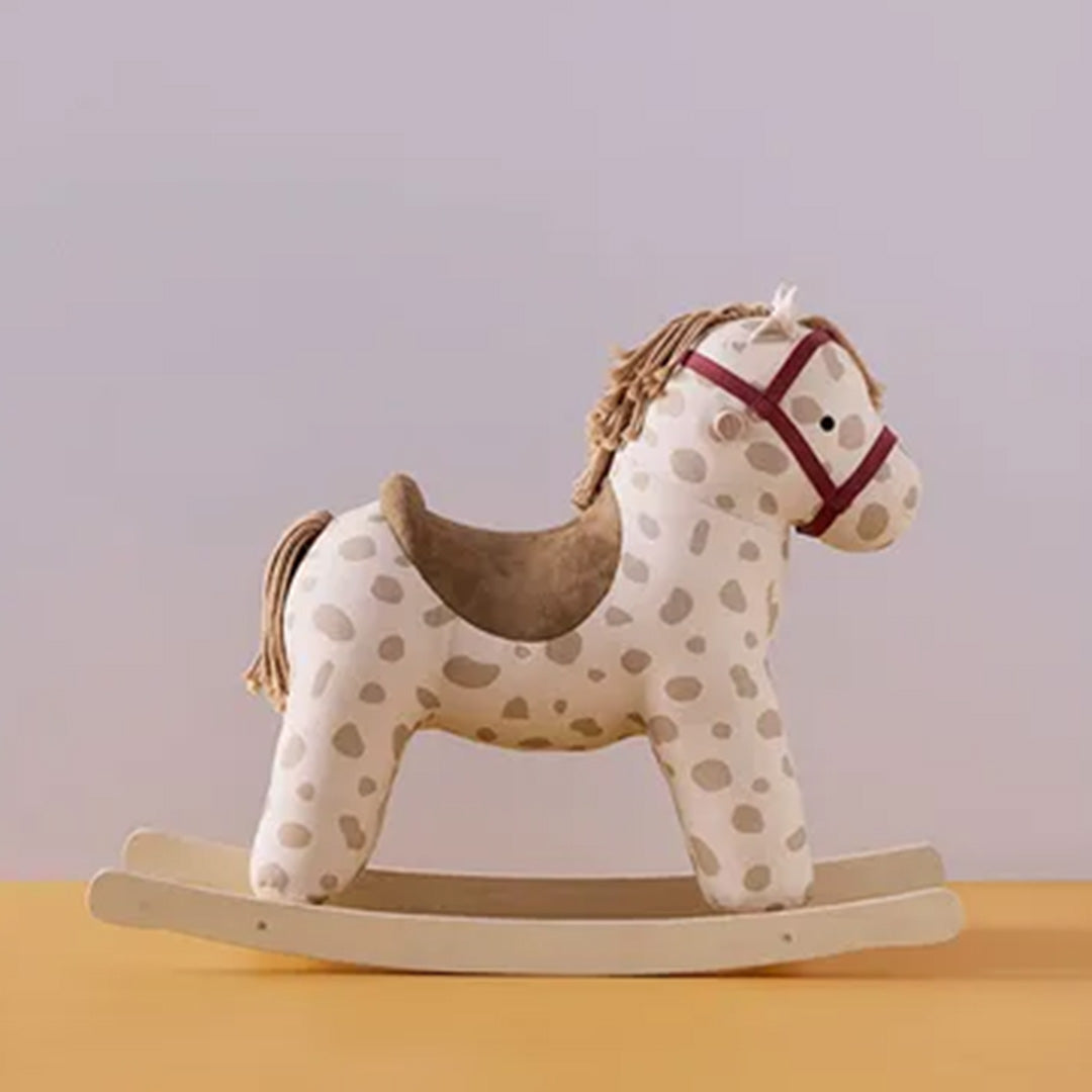 Kids Concept hobbelpaard met stippenpatroon en rode teugels, van de zijkant gefotografeerd tegen een lichte achtergrond.