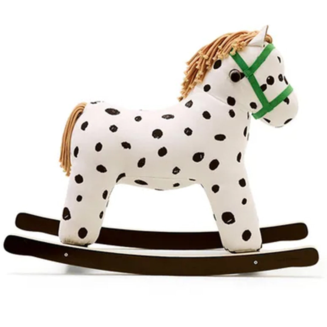 Kids Concept hobbelpaard Pippi, wit met zwarte stippen en groene hoofdstel, schuin gefotografeerd.