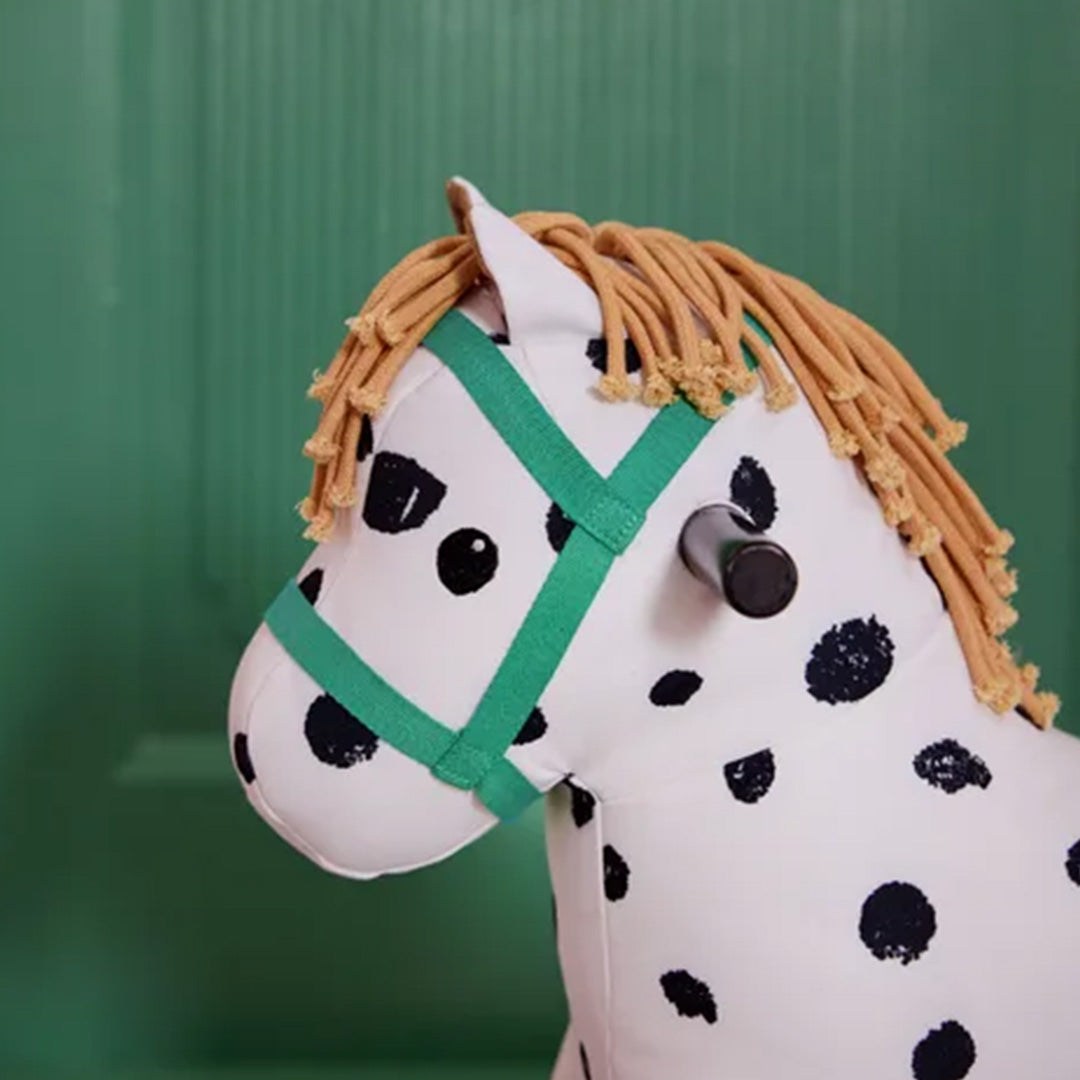 Detailopname van de kop van het Kids Concept hobbelpaard Pippi, met groene hoofdstel en bruine manen.