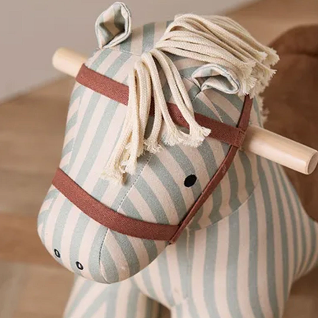 Detailopname van de kop van het Kids Concept gestreepte hobbelpaard met manen en hoofdstel.