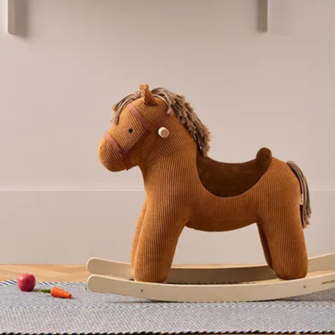 Kids Concept bruin corduroy hobbelpaard in een kinderkamer met speelgoed op de vloer.