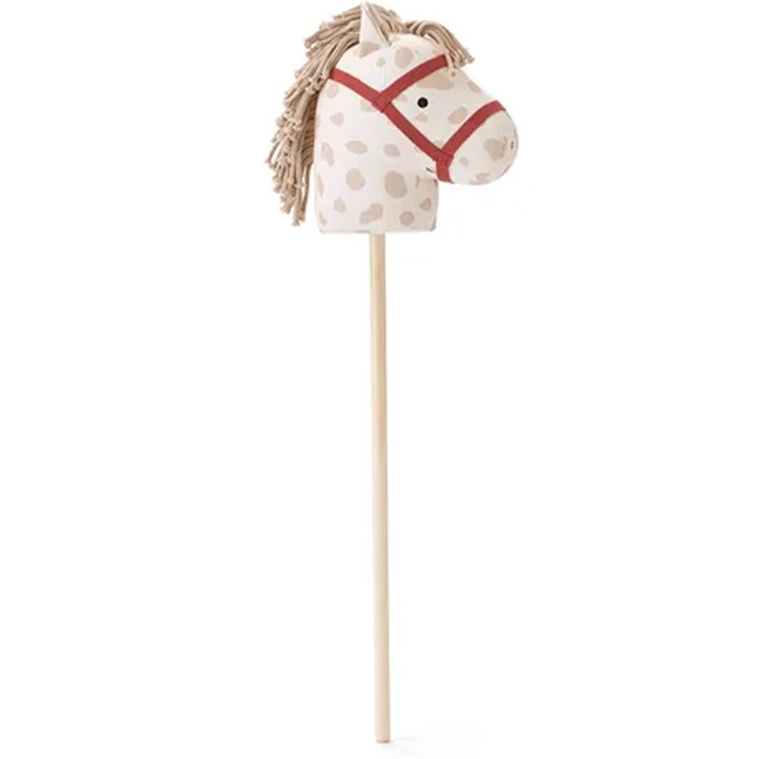 Kids Concept stokpaard Dotty met beige stof met stippen, rode hoofdstel en houten stok.