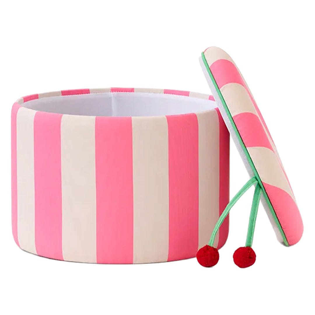kids concept opbergpoef met roze en witte strepen, waarvan de deksel met rode pompons deels open is.