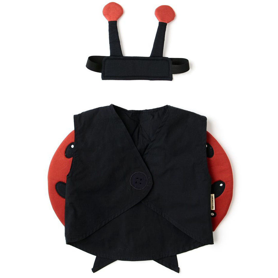 Kids Concept kinderkostuum lieveheersbeestje, plat gefotografeerd, met een zwarte vest, rode vleugels en een hoofdband met voelsprieten.