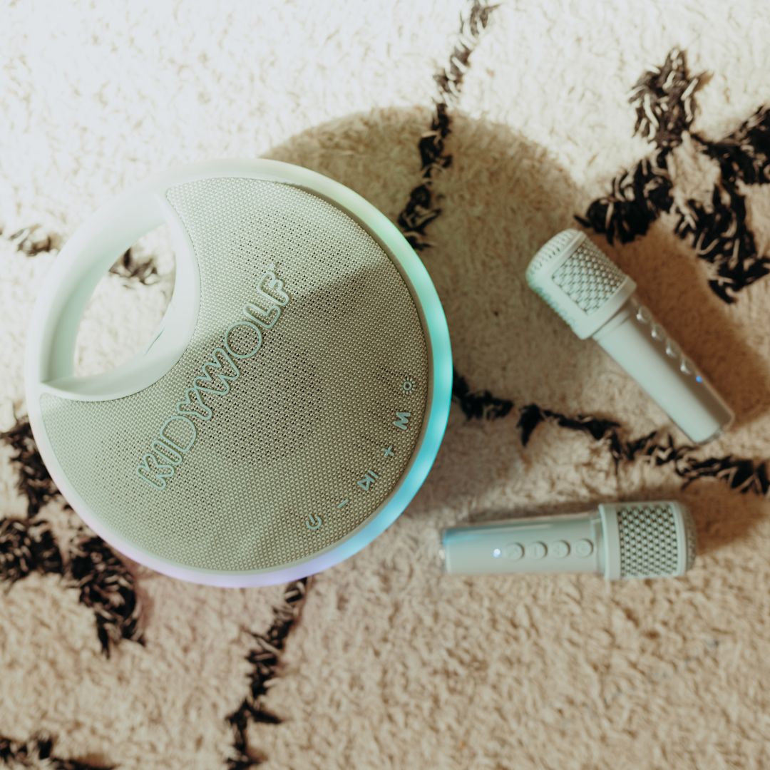 De Kidywolf karaokespeaker en twee microfoons liggen op een pluizig tapijt.