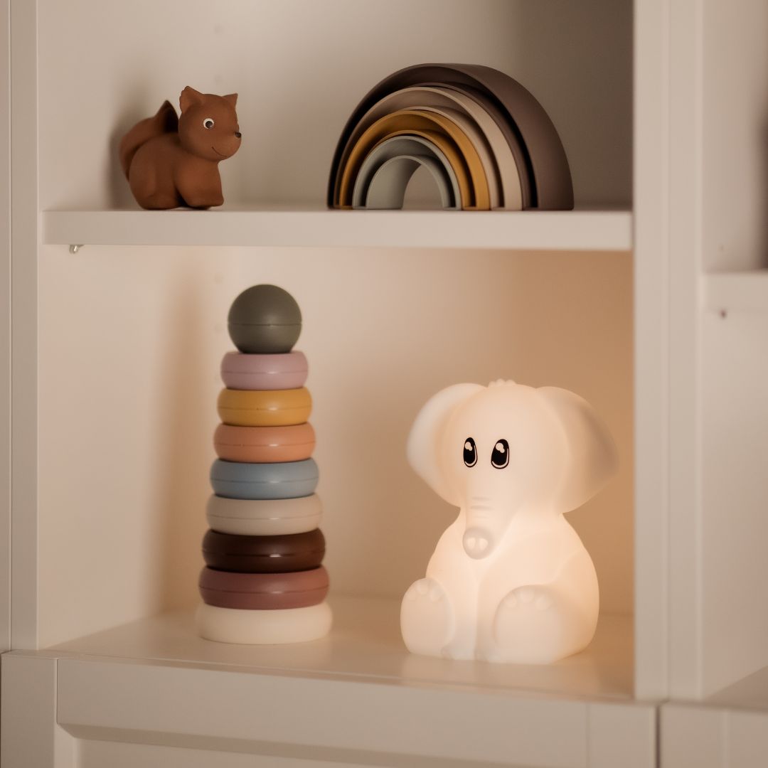Kidywolf olifant nachtlampje dat zacht wit licht geeft op een witte plank.