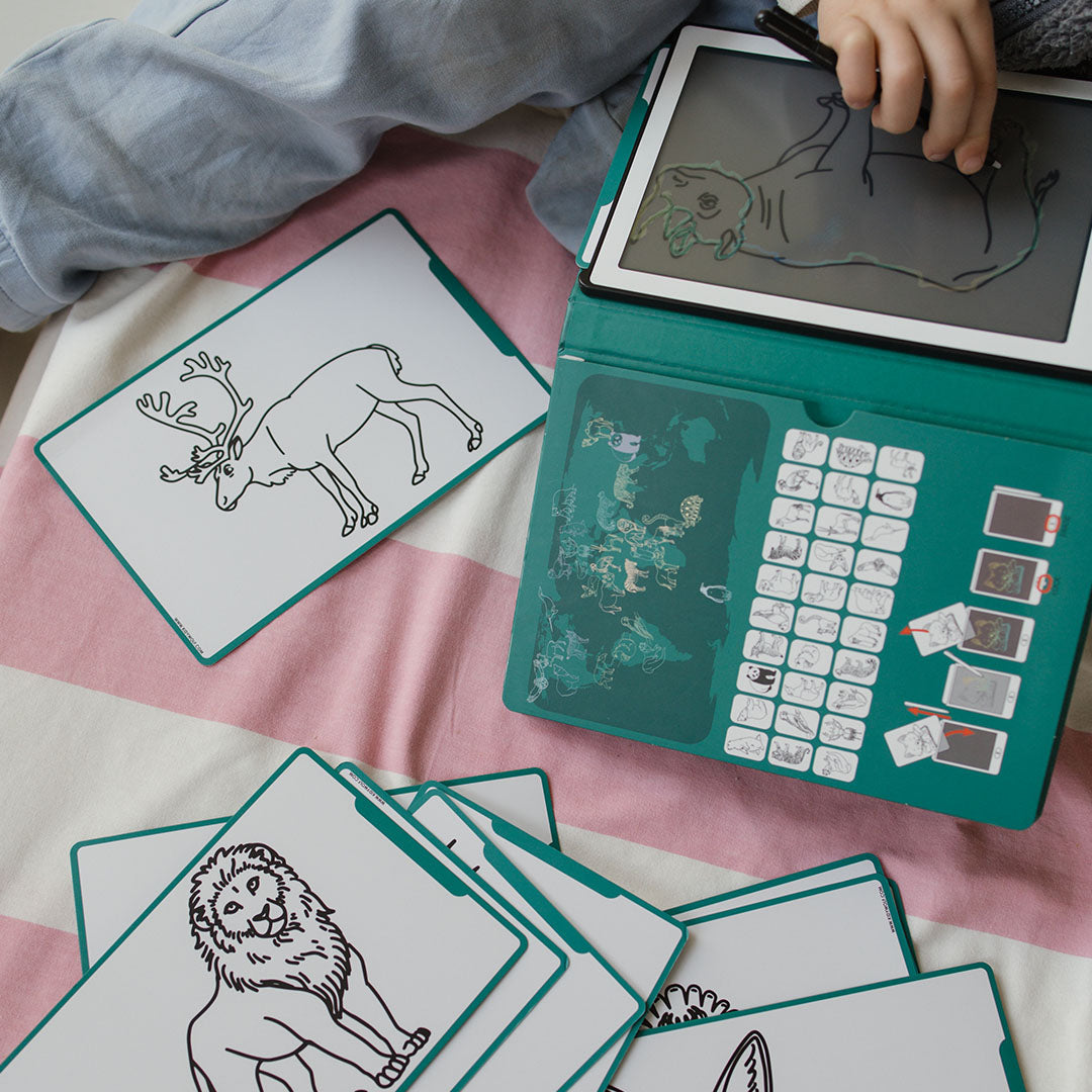 Een kind tekent een dier op het Kidywolf KidyDraw Mini speelgoedtekentablet, met voorbeeldkaarten van dieren ernaast.