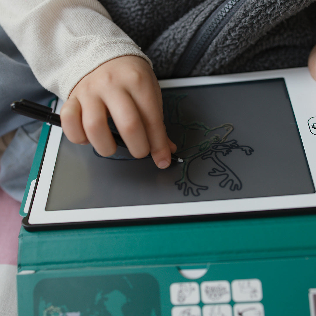 Een kinderhand tekent een kikker met de stylus op het Kidywolf KidyDraw Mini speelgoedtekentablet.