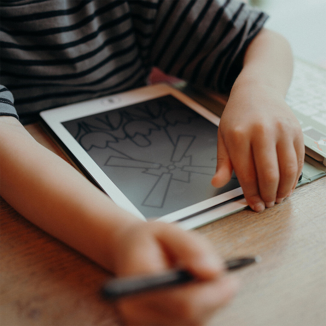 Detail van kinderhanden die een molen tekenen op een Kidywolf Kidydraw Mini tekenbord.