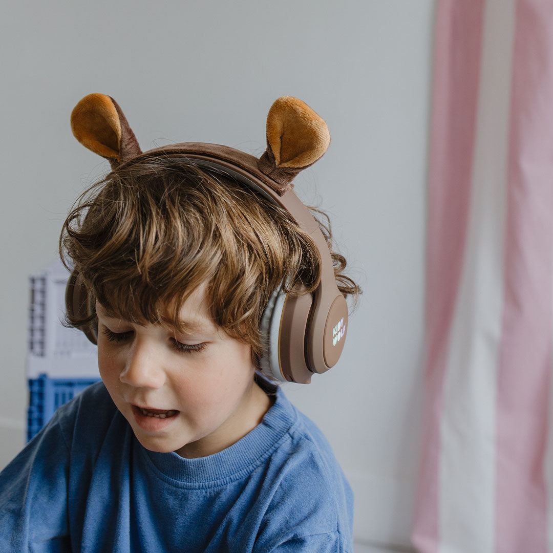 Een jongen draagt de Kidywolf kinderkoptelefoon met berenoren.