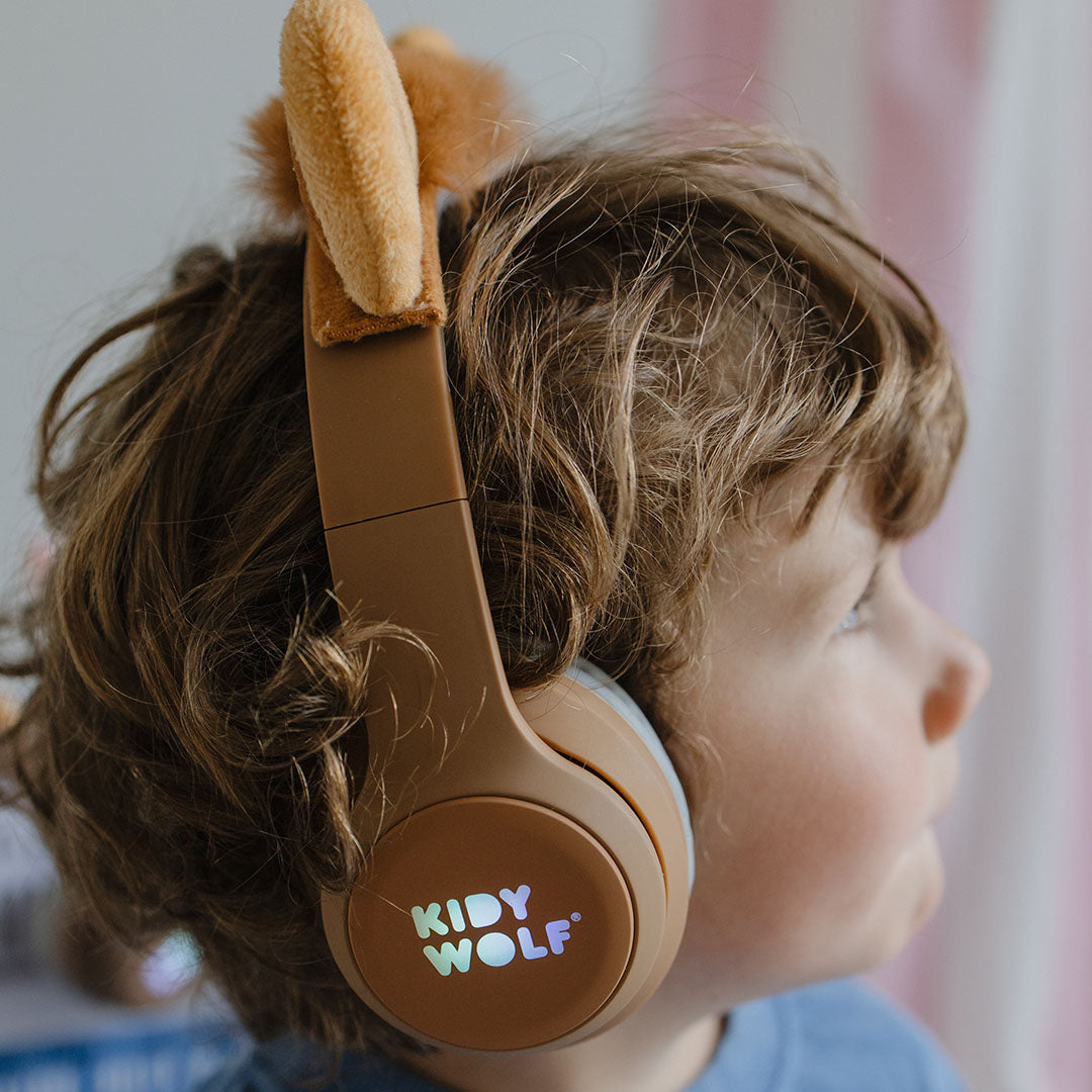 Detail van een kind dat de bruine Kidywolf kinderkoptelefoon met leeuwenoren draagt.