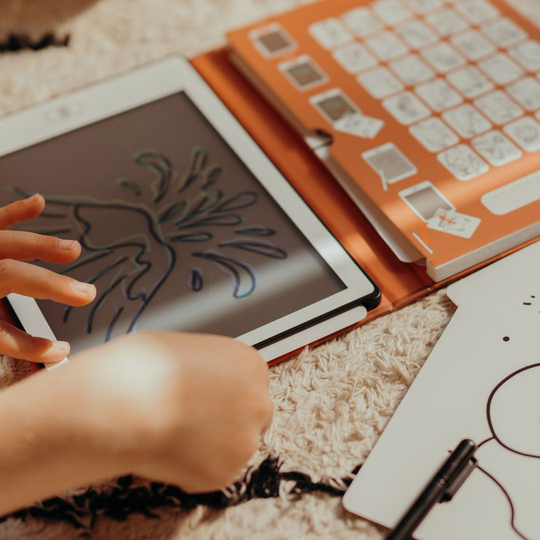 Kinderhanden tekenen een blauw figuur op een Kidywolf Kidydraw Mini tablet.
