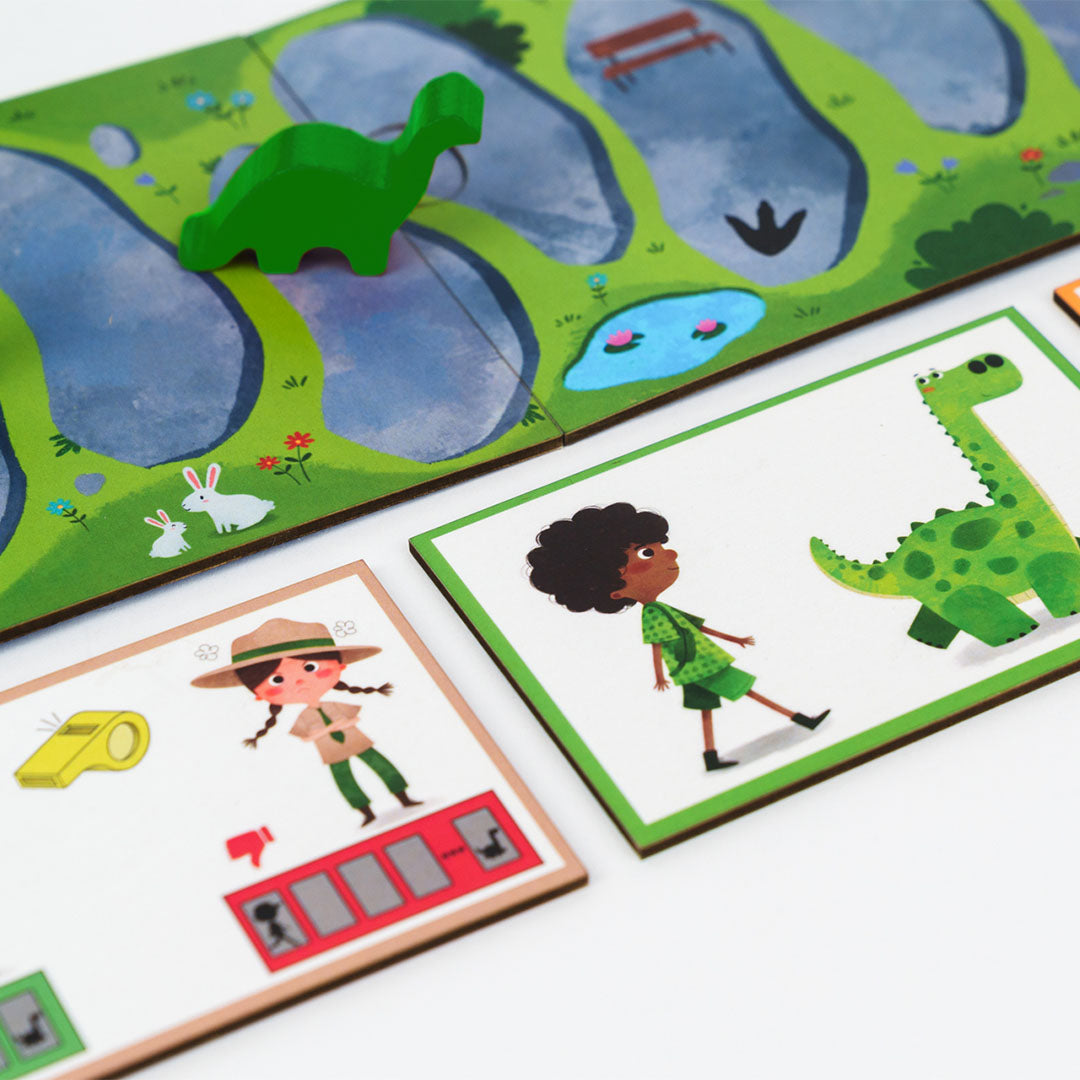 Detail van het Kiwizou BalaDino bordspel met een groene dinosaurus speelfiguur en twee geïllustreerde speelkaarten.