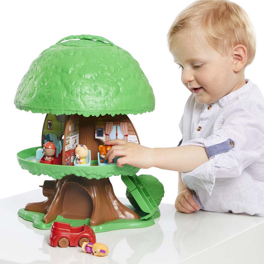 Een peuterjongen speelt met de open Klorofil speelboom met dierenfiguren en meubeltjes.