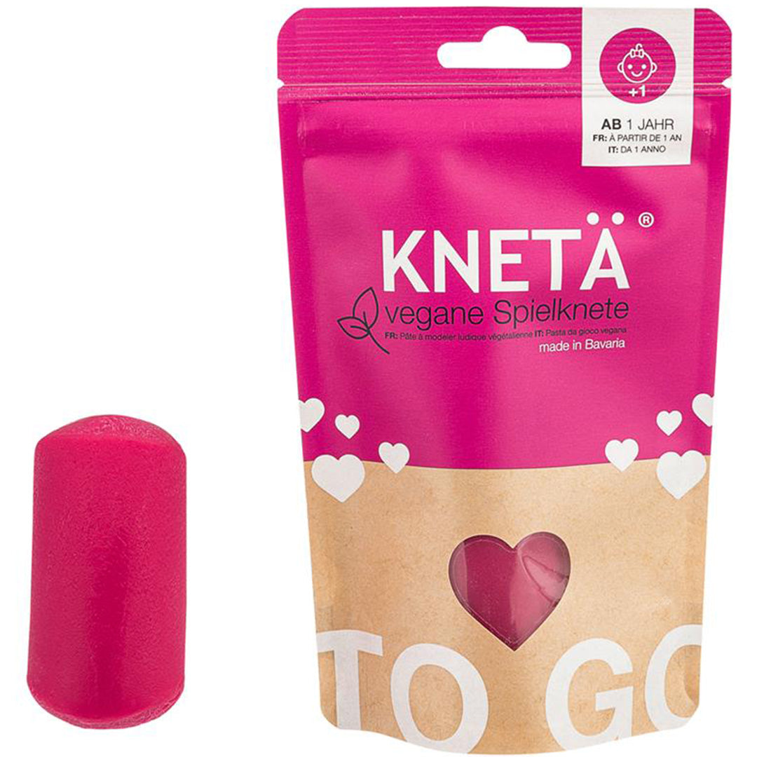 Een roze verpakking Knetä vegan speelklei naast een roze kleiblok.