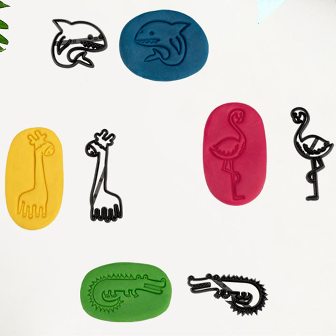 Vier zwarte dieren uitsteekvormen en vier stukken klei in blauw, geel, rood en groen met de afdrukken van de dieren.
